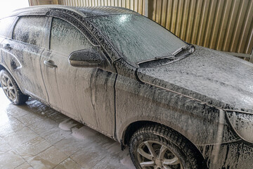 Washing the car with shampoo and foam. Selective focusing shot