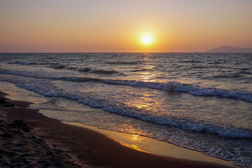 Obraz premium A sunset over the sea with waves