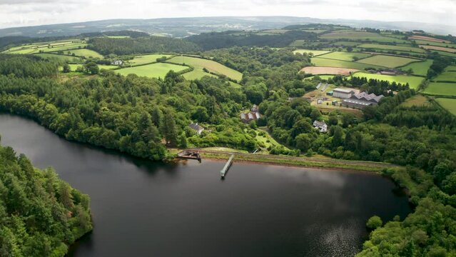 Water catchment reservoir with concrete dam revealing distant rainy views