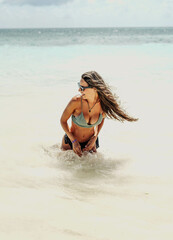 Mujer de vacaciones refrescandose en una playa del caribe