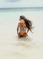 Mujer de vacaciones refrescandose en una playa del caribe