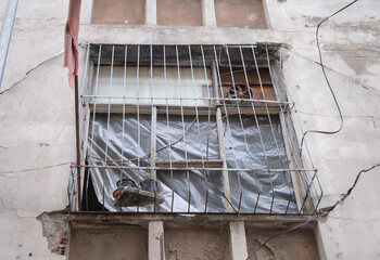 rusty iron cage in front of window in old building