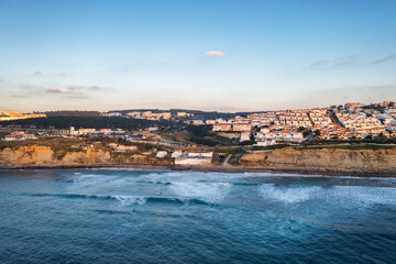 Obraz premium Ericeira drone aerial view on the coast of Portugal with surfers on the sea at sunset