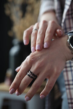 Close up of oil for cuticula on woman's hands, black background
