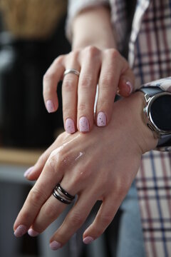 Close up of oil for cuticula on woman's hands, black background