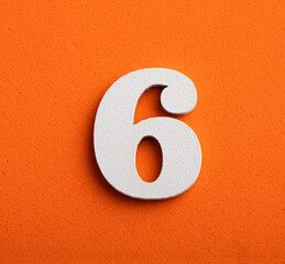 Number six - white number in wood on orange background