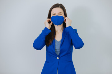 Young woman wants to put on a ffp2 protective mask. Cheerful business woman or teacher shows her ffp2 protective mask. Wearing mask in office