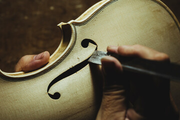 Unrecognized luthier creating a violin and using tools