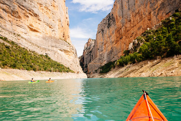 View of a canyon with a group of  kayakers navigating it.