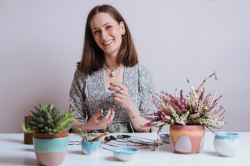 Portrait of artisan woman making handmade gemstone jewellery, home workshop. Women artisan creates jewellery. Art, hobby, handcraft concept