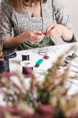 Woman hands making handmade gemstone jewellery, home workshop. Women artisan creates jewellery. Art, hobby, handcraft concept