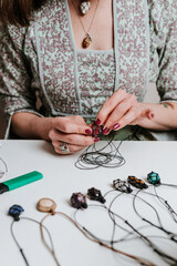 Woman hands making handmade gemstone jewellery, home workshop. Women artisan creates jewellery. Art, hobby, handcraft concept