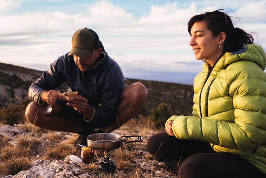Young couple cooking during a camping trip in the mountains.