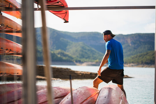 Young man doing maintenance work at a kayak rental company.