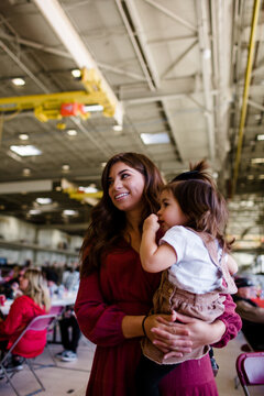 Mom Holding Daughter for Military Homecoming in San Diego