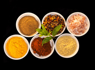 Liven up any dish. Shot of an assortment of colorful spices against a black background.