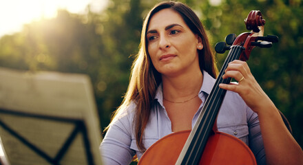 Music is the perfect way to calm the soul. Cropped shot of a beautiful woman playing a cello in the...