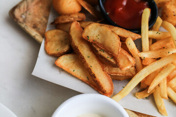 Potato fries or French fries with ketchup on wooden table background. Homemade roasted in the oven