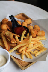Potato fries or French fries with ketchup on wooden table background. Homemade roasted in the oven