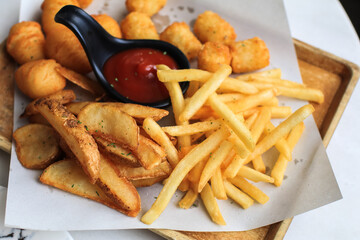 Potato fries or French fries with ketchup on wooden table background. Homemade roasted in the oven