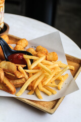 Potato fries or French fries with ketchup on wooden table background. Homemade roasted in the oven