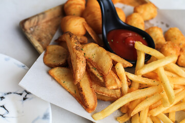 Potato fries or French fries with ketchup on wooden table background. Homemade roasted in the oven