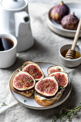 Two sandwiches with figs, thyme on textured background. Breakfast composition