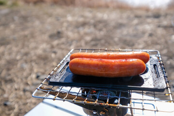 キャンプでソーセージを小さい鉄板で焼く