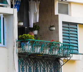 Macau appartement balcony with person, clothes hanging on a cothesline and potted plants 