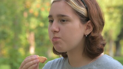 a teenage girl with an Asian appearance chews up leftovers and laughs with crumbs from her mouth. selective focus