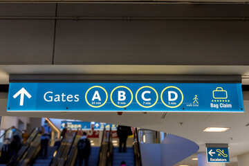 Airport sign board Gates A B C D Baggage Claim in air terminal