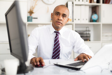 Successful businessman working with papers and laptop in office