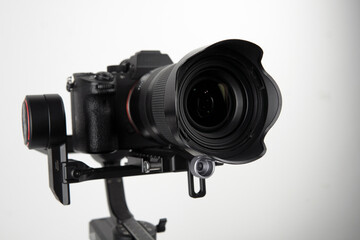 photographic camera in a steadicam on a table with a white background