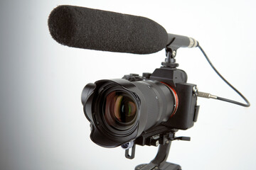 mirrorless camera and a connected microphone mounted on an electronic stabilizer on a white...