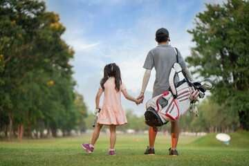 Brother takes his sister's hand to play golf.