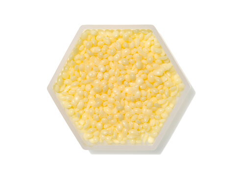 Candelilla Wax in hexagonal molecular shaped container on white background.