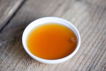 fish sauce on white bowl on wooden background, fish sauce obtained from fermentation fish or small...