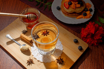 Anise tea served in a glass. Anise tea to accompany breakfast of hotcakes.