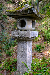 Stone lanterns covered in moss at Horaiji Temple, a Buddhist temple on Mount Horaiji. The lantern is a symbol of illumination, a guiding light.