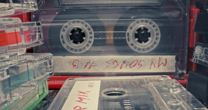 Cassette in red player with headphones. Player and spinning cassette.