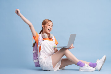 Young Asian student posing on blue background