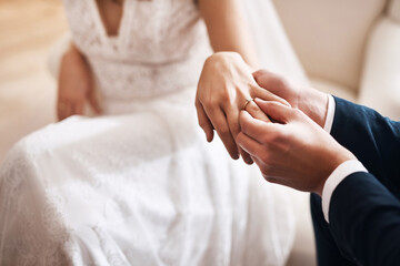 Heres to forever. Cropped shot of an unrecognizable groom putting a diamond ring on his wifes...