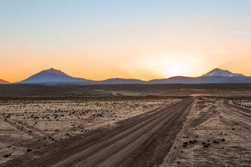 Fototapeta na wymiar Deserto do altiplano boliviano, estradas de terra e montanhas andinas no horizonte