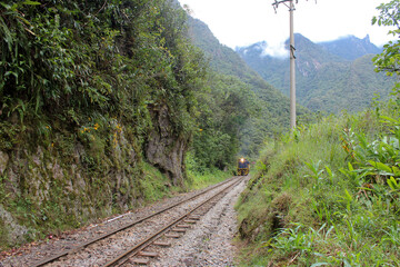 Estrada de ferro, vendo-se à distância o a máquina do trem com farol aceso.
Estrada que leva a...