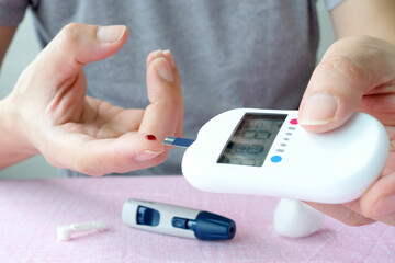 hand of people check diabetes and high blood glucose monitor with digital pressure gauge....