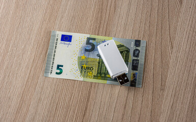 memory usb flash drive on a euro banknote on a wooden backdropo close up, information security concept