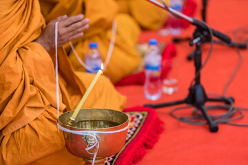 Buddha monk hold candlestick above holy water bowl. religion ceremony. Buddhist holy water. 