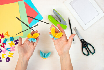 Butterflies with their own hands from colored paper. Step-by-step instructions, top view. Step 16.