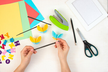 Butterflies with their own hands from colored paper. Step-by-step instructions, top view. Step 19.