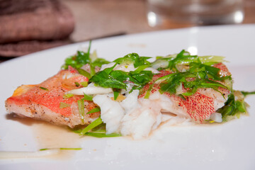 Steamed red fish with green herbs.